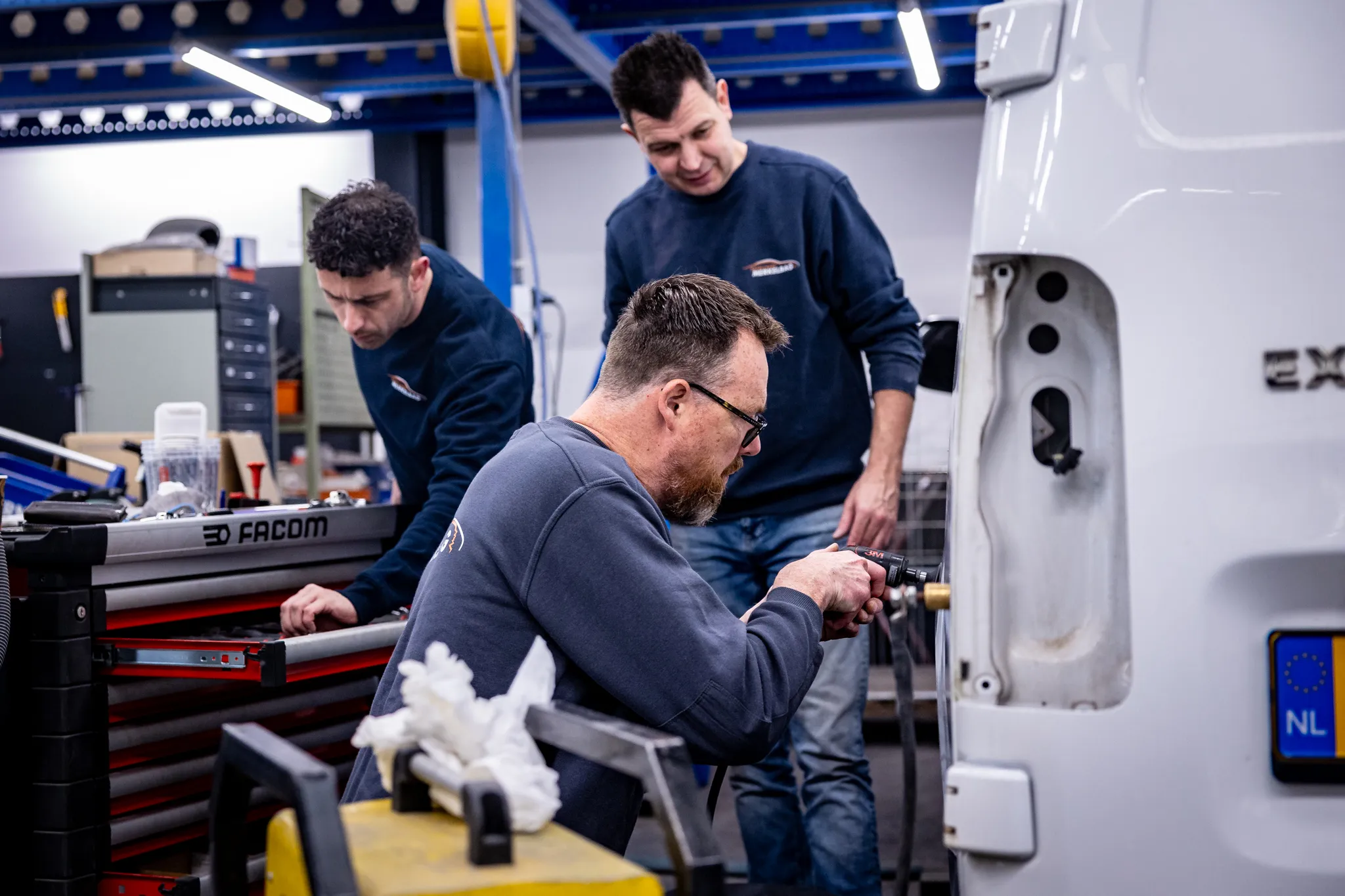 Collegas werken aan een bestelwagenreparatie