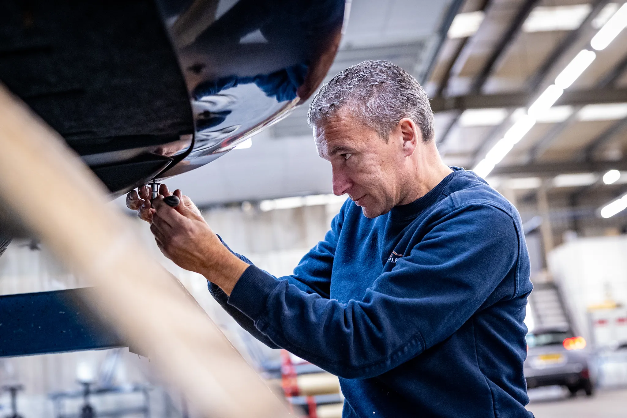 Monteur werkt aan een onderstelreparatie
