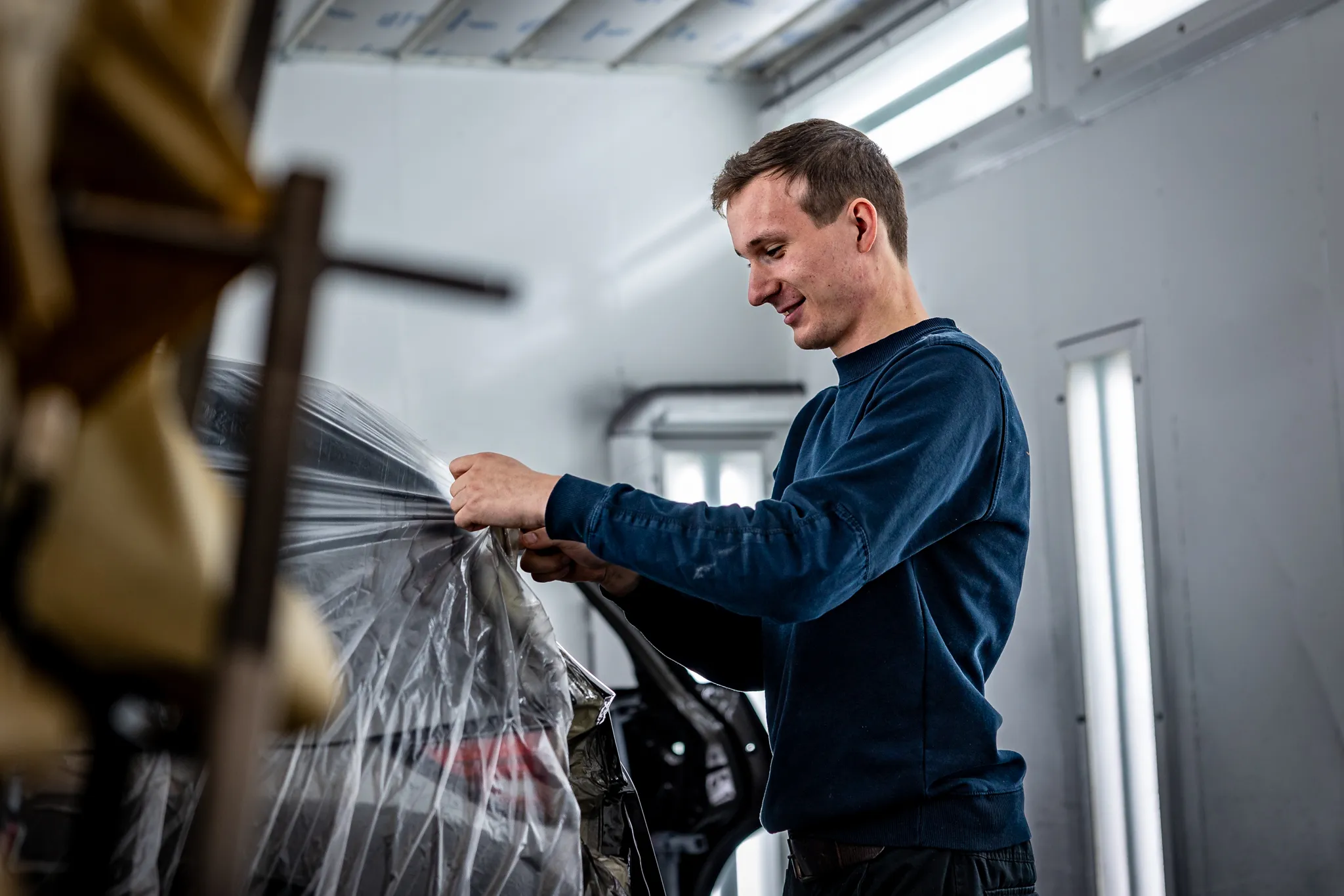 Autospuiter plakt een auto zorgvuldig af met folie